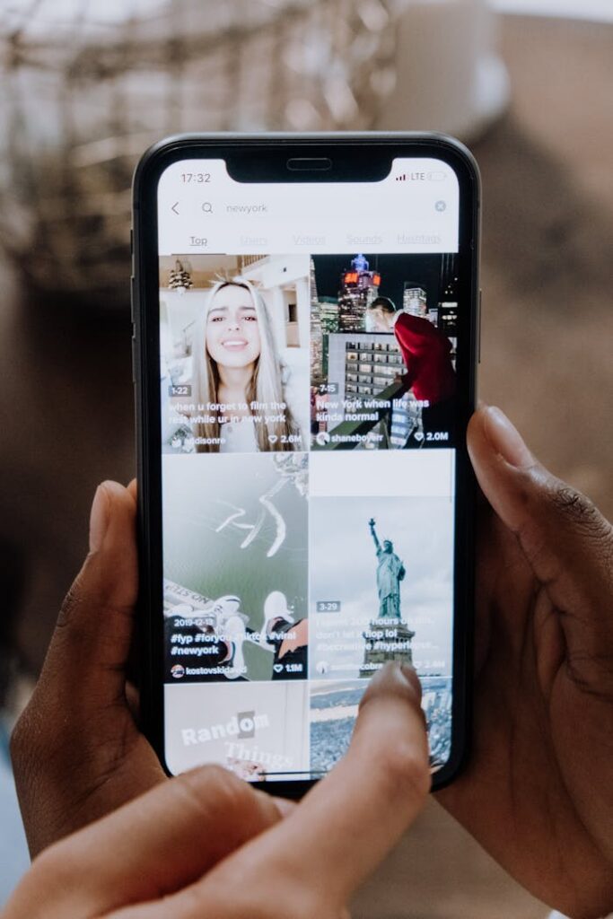 pexels photo 5081917 Close-up of a person using a smartphone to browse a social media app indoors.